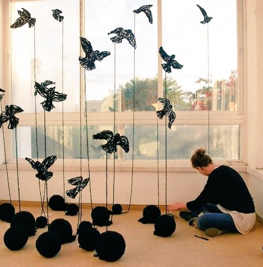 Artist Maya Gelfman uses yarn as she works on her "Black Birds" installation #UnravellingWomensArt