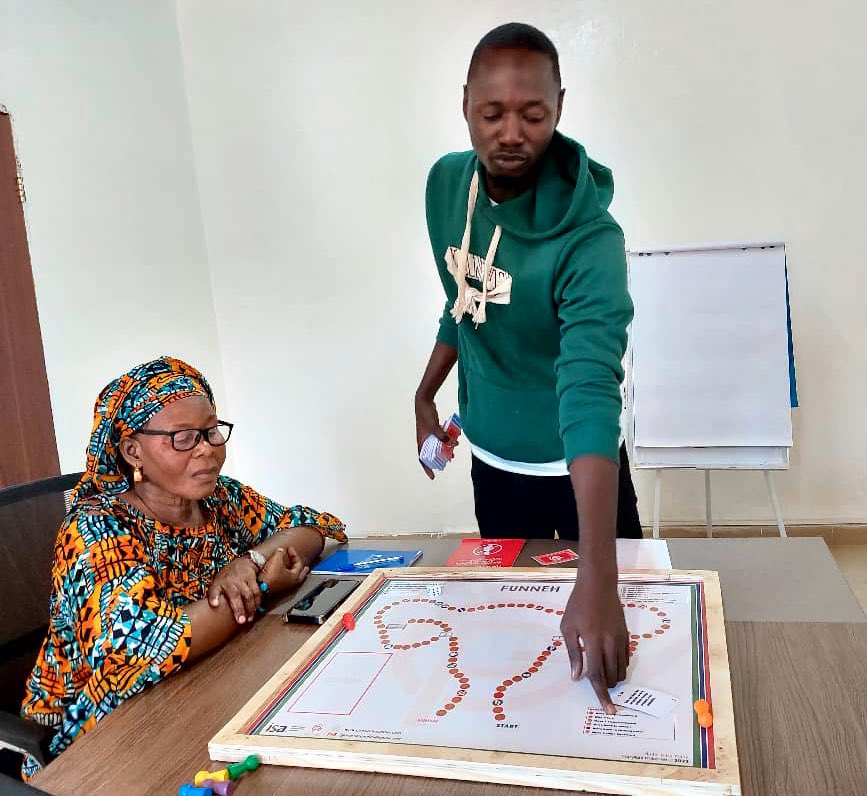 GirlsPrideGam's tweet image. Alagie Gaye, Field Coordinator for #SSWH demonstrating to his team members and project supervisors how to use the Funneh board game to learn about Teenage Pregnancy &amp;amp; Child Marriage.
#Evaluation #SimulationExercise #ToT #Gamification #TabooTopics
#SSWH #EarlyMarriageProject #IDRC
