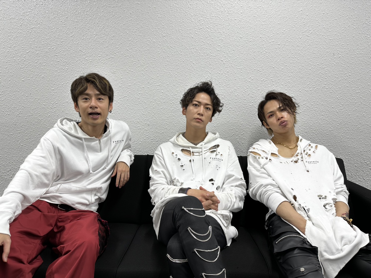The members of #KATTUN catch their breath on a couch backstage
