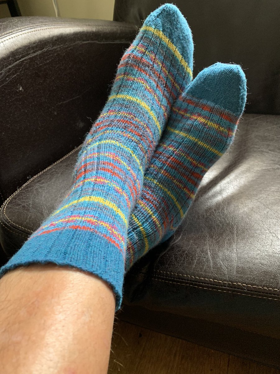 LivRunsFast's tweet photo. Socks for Dad🧦, modelled by partner, and in to the bath. Variation on Nice Ribbed Sock in Regia Design line. Technically, these are the #sockalong ✅ March socks. Estimated delivery time to US between 1 day - 6 months by the time I get them packed and mailed 😬. #KnittingTwitter https://t.co/J3bSR0ziFS