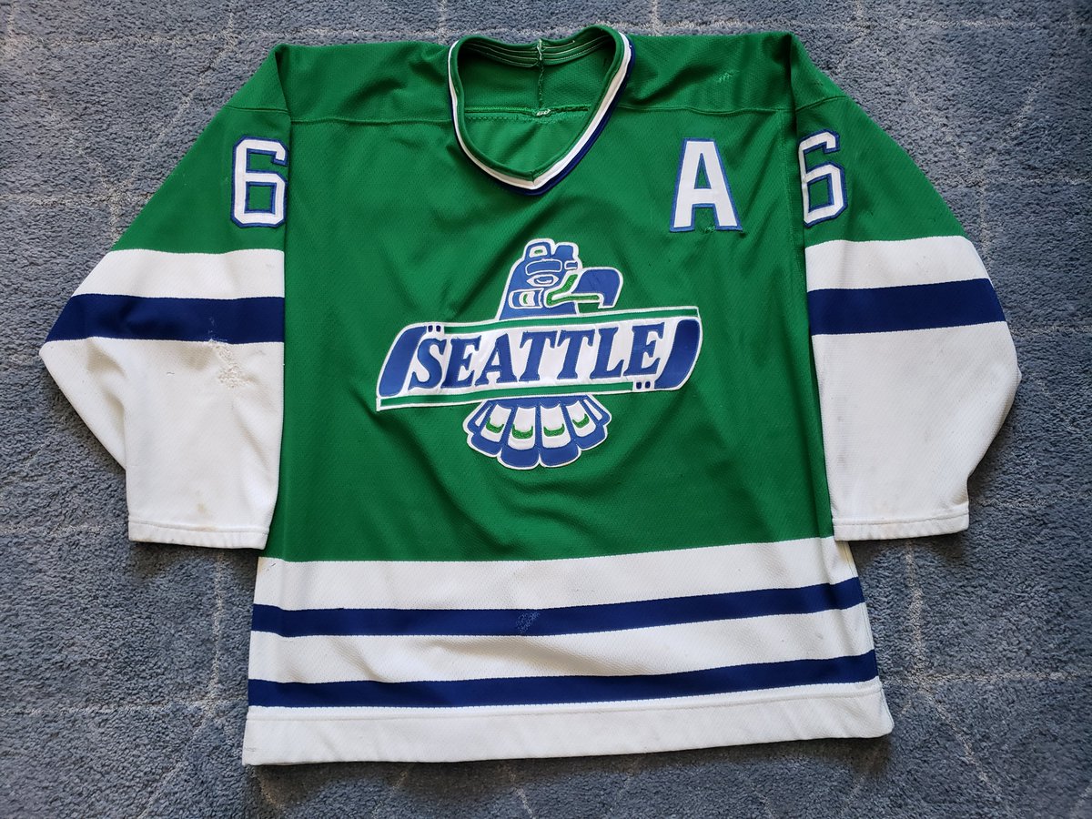 2RogueDubRacks's tweet photo. In honor of game 5 of the WC Finals tonight we show one from the Home team. This @SeattleTbirds road green was worn by defenceman Stewart Malgunas during the 1989-90 season. This jersey is the key to the John Sumida collection, and my honor to have on the racks!! Lets Go Birds!! https://t.co/wLzg4myKrh