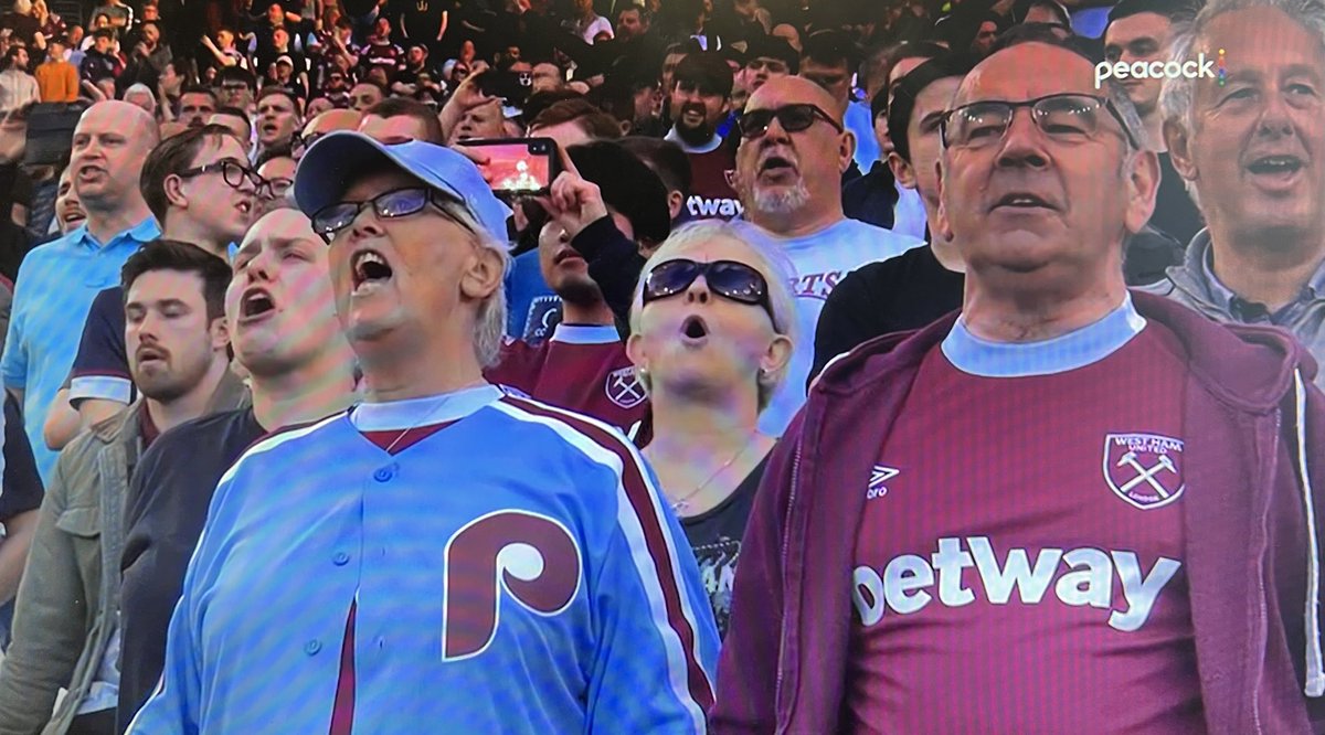 thetrentlowe's tweet photo. Weird uni mashup. West Ham’s colors are maroon and light blue, so this fan wore a @Phillies throwback, hat and all. Thought she might be American, but then she belted out God Save the King. Why not just wear a West Ham kit? @UniWatch @PhilHecken https://t.co/Dr7n3ARkCJ
