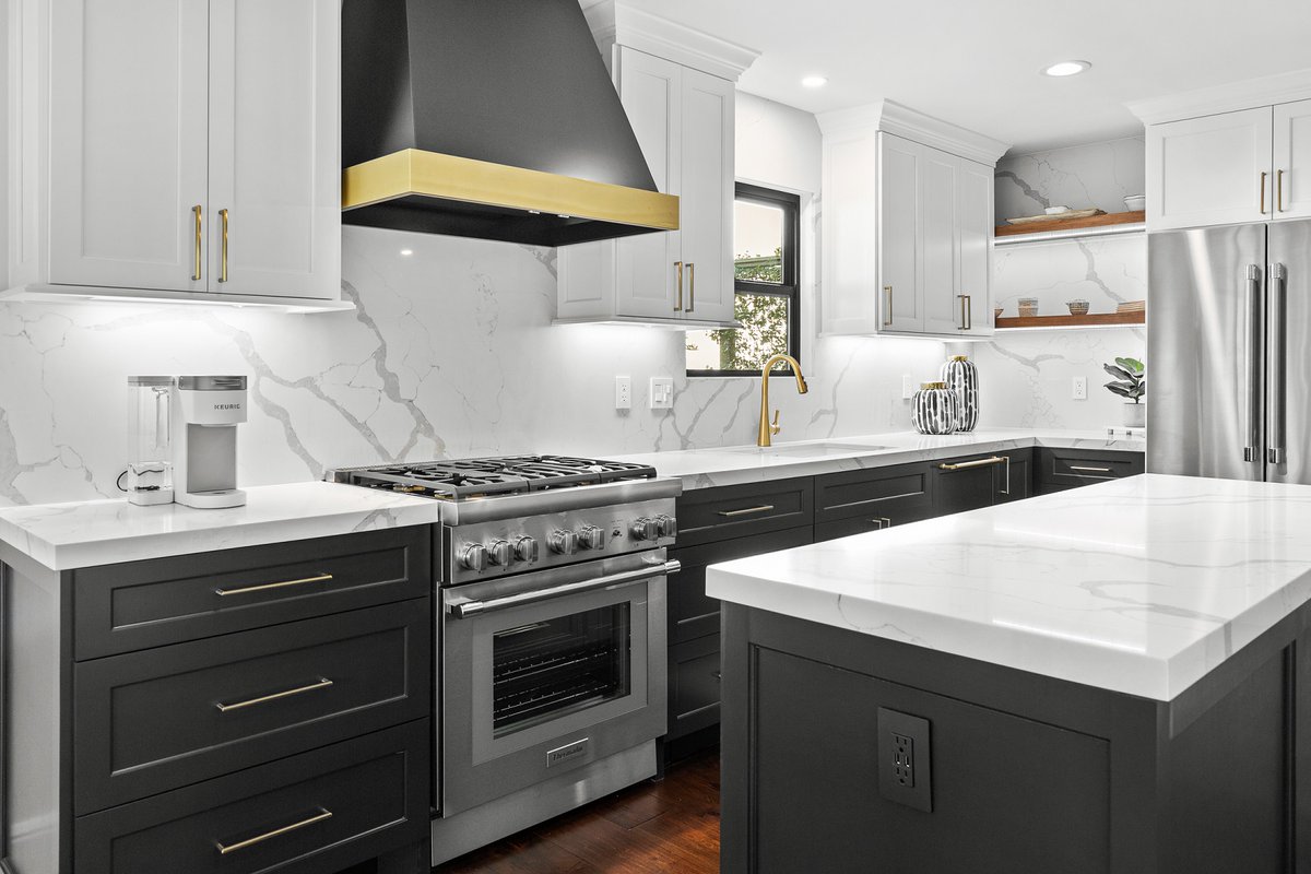 We are loving this kitchen remodel we recently finished! White and black cabinets, gold fixtures and hardware, and a black and gold metal range hood give the classic combination a modern twist.  #scmdesigngroup #thewoodlandstx #kitchendesign #kitchenremodel #goldhardware