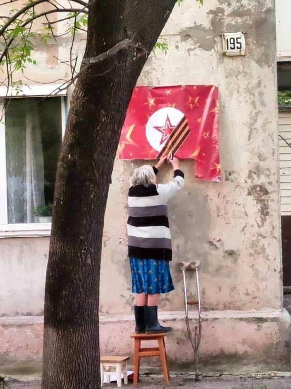 tweet4anna's tweet photo. Meantime in Mariupol an elderly Ukrainian woman (possibly with a disability) is cutting a soviet/russian flag with scissors.

This contrast angers and breaks my heart at the same time. 

russians have no idea what’s suffering is. https://t.co/UFT2m68zUm