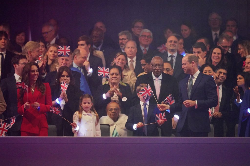 isaguor's tweet photo. Not Prince William putting the flag in prince george and princess charlotte's faces aahahahaha. He is such a dad.

#coronationconcert https://t.co/qB2JFRdabr