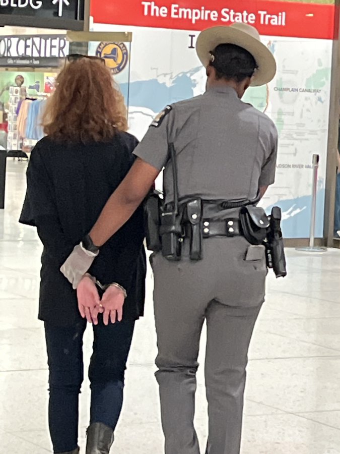Actor Susan Sarandon in handcuffs being led away by police.