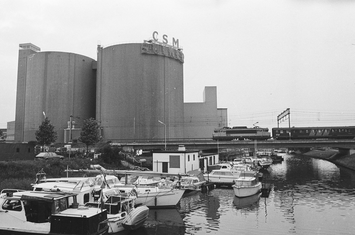 breda's tweet photo. BREDA TOEN 🔙 &amp; 🔜 NU. De Markkade in 1985 vs vandaag! We kijken naar de oude suikersilo's van suikerfabriek CSM. Het terrein van de suikerfabriek heet nu 't Zoet en wordt de komende jaren herontwikkeld tot stadswijk. 
📸 Stadsarchief Breda, Johan van Gurp https://t.co/bLEEaNmB5B