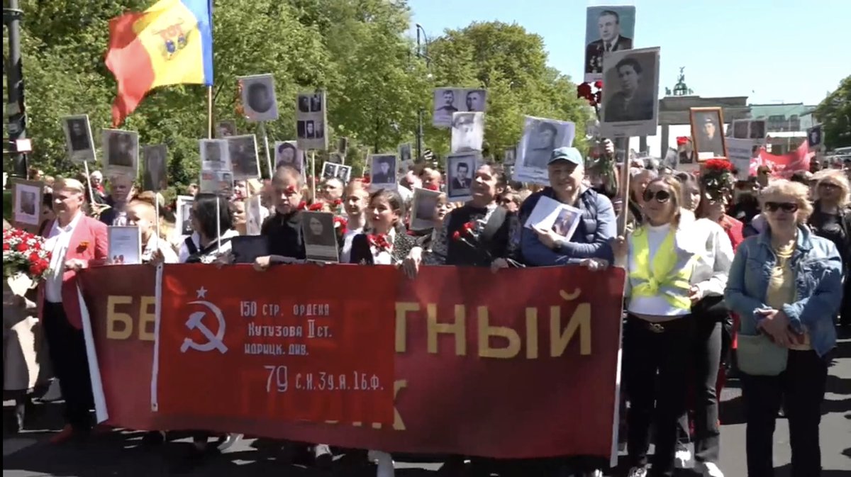 Happening now in Berlin: hundreds of people commemorating May 9, Soviet Victory Day, march past the Brandenburg gate. They are singing Katushya, they also sang «нам нужна одна победа» by Bulat Okudzhava. Russian flags &amp; pro-war symbols were banned last week by German authorities.