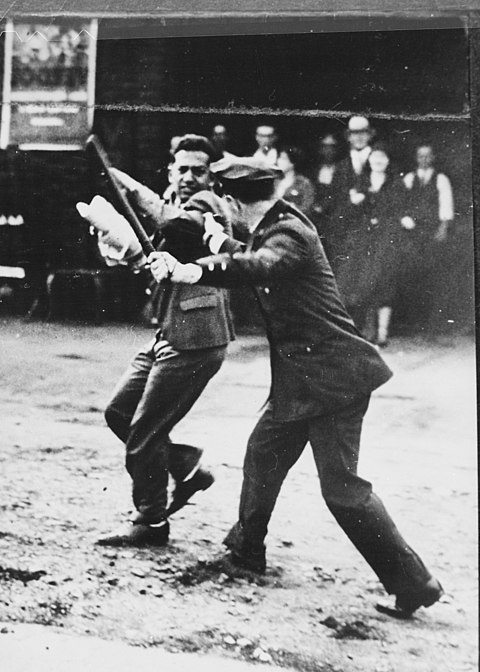Confrontation between a policeman wielding a night stick and a striker during the San Francisco General Strike, 1934. By Unknown author or not provided - U.S. National Archives and Records Administration, Public Domain, https://commons.wikimedia.org/w/index.php?curid=17057595