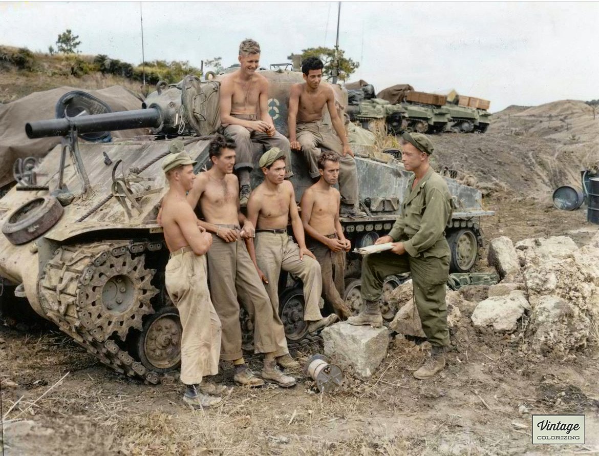 Colorizer2's tweet image. In juli 1945 bekijken zeven Amerikaanse soldaten van de 763e Tankbataljon van de 96e Infanteriedivisie hun tactieken die ze hebben gebruikt tijdens de slag om Okinawa in voorbereiding op de invasie. Deze foto is ingekleurd door vintagecolorizing.com.