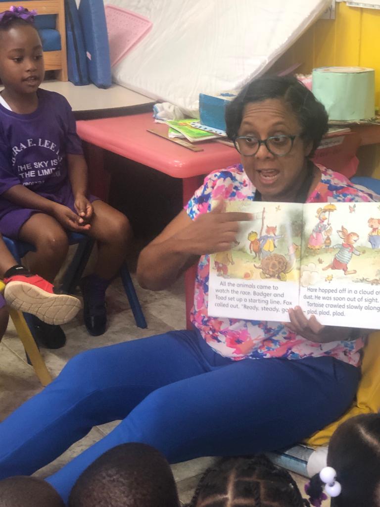 Andrea58383539's tweet photo. Ms. Denise Johnson, Principal at Barbara E. Lee Hing Banana Ground Basic School, reads for the children #ReadingMatter #Read4Ja @ECCJA @Nov_Forbes1 #12StandardsMatter https://t.co/chlqnqyjM2