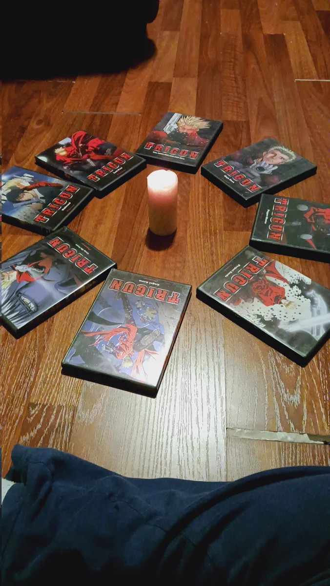 John remembers he still has all of Trigun on DVD and creates a prayer circle out of the boxes, with a lit candle on the center. 