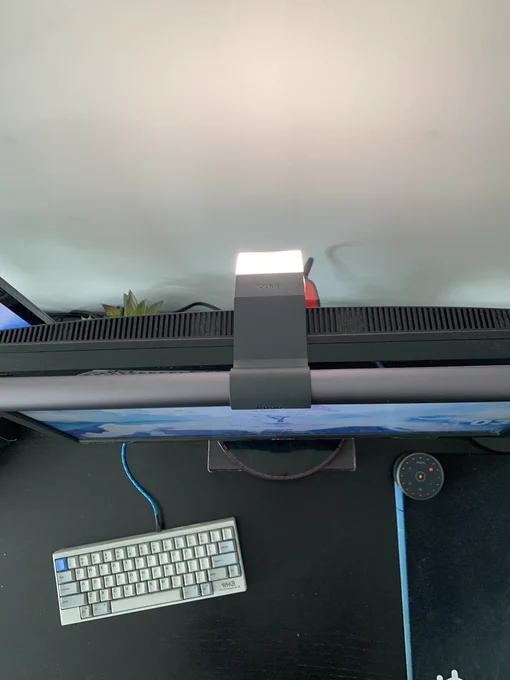 Top view of the BenQ ScreenBar Halo lightbar sitting on top of a monitor and lighting up a desk