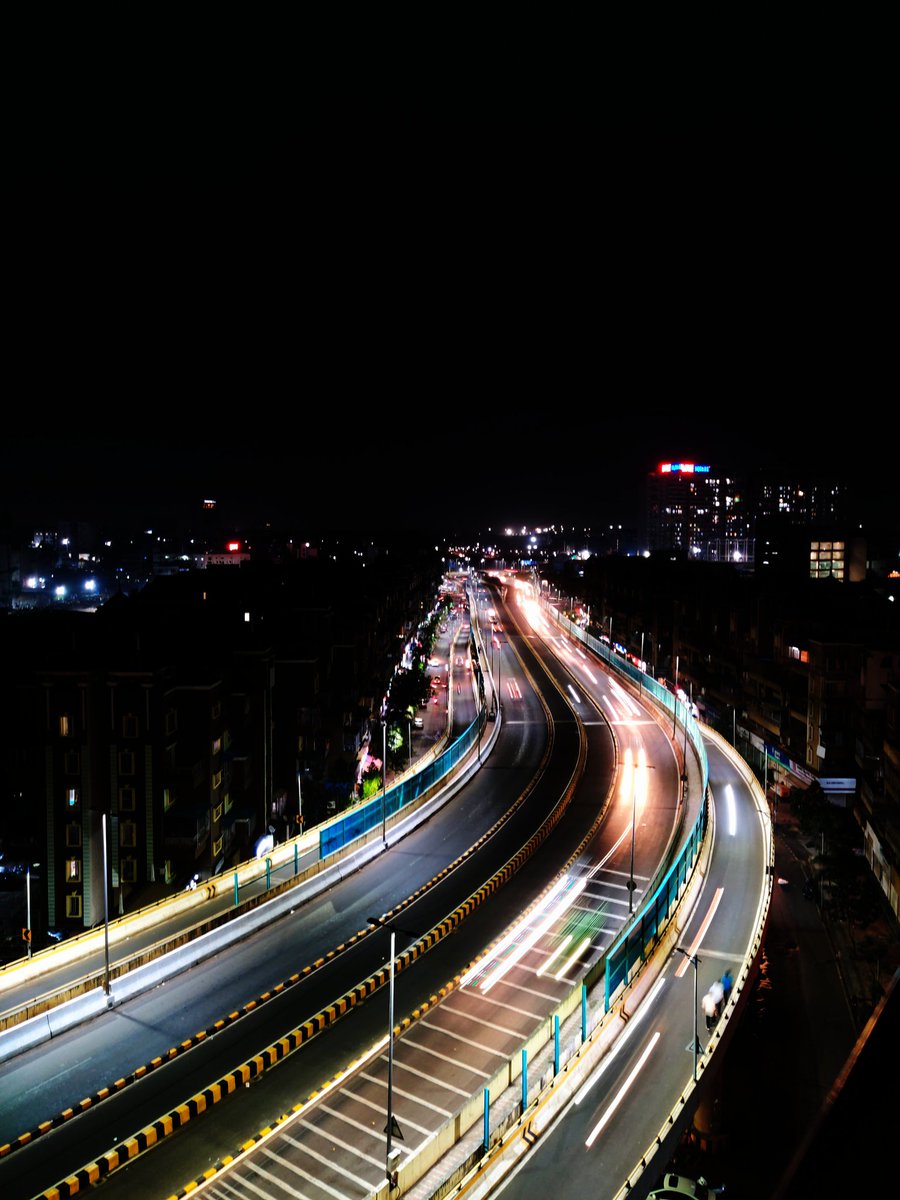 Capturing the mesmerizing glow of city lights, the light trails dance as vehicles zoom by on the flyover. A nocturnal symphony of motion and illumination, reminding us of the vibrant energy that never sleeps. #NightLights #CityLife #LightTrails #UrbanVibes