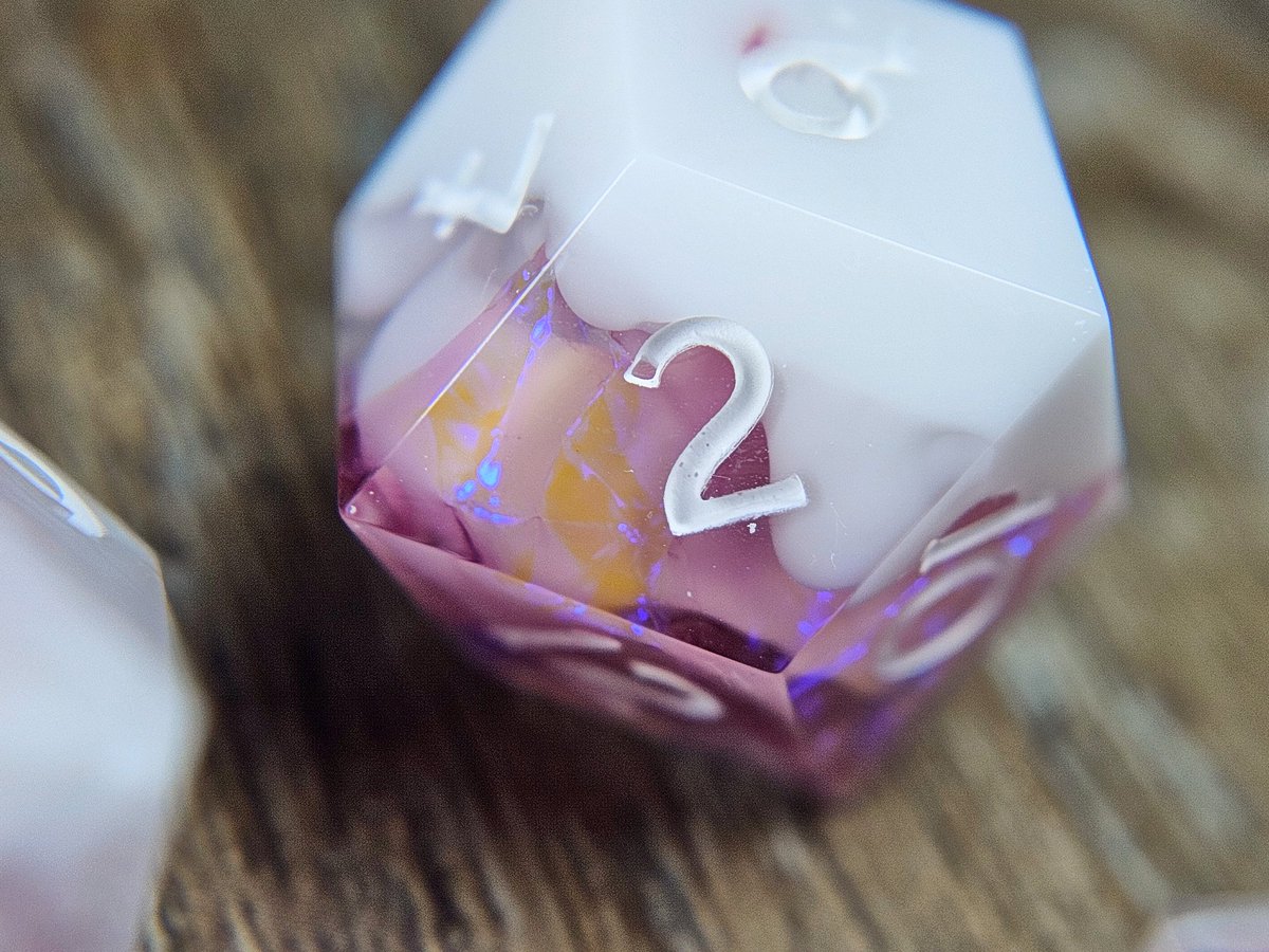 Frozen Raspberry 

A dice set with plume-y drips of opaque white floating around and engulfing warm pink mylar inclusions with a bright blue/indigo flash! Available this Thursday (25 May) in the next shop update.

#dice #dicemaker #handmadedice #sharpedgedice #ttrpgdice #dnddice