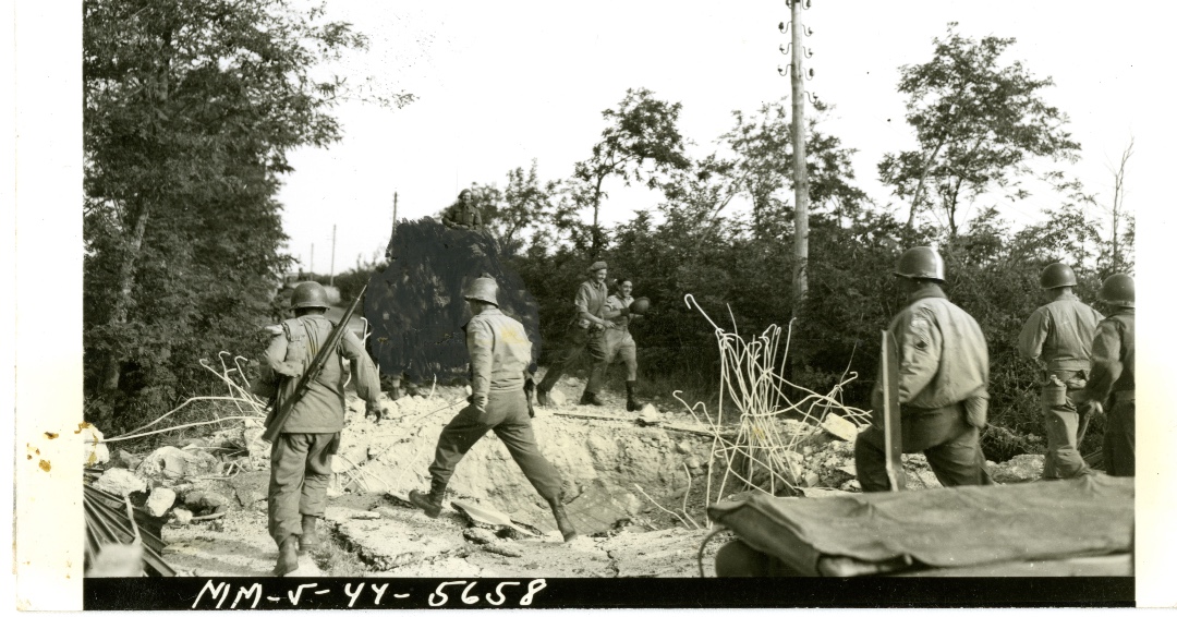 Official caption on reverse: American M-10 tank destroyer has just fired into the Galleria di Mont Orso Tunnel, west of Fondi, to blast out two German battalions trapped inside. Infantryman crouches beside machine gun, ready to open fire if Nazis show fight. 

#WeRememberThem