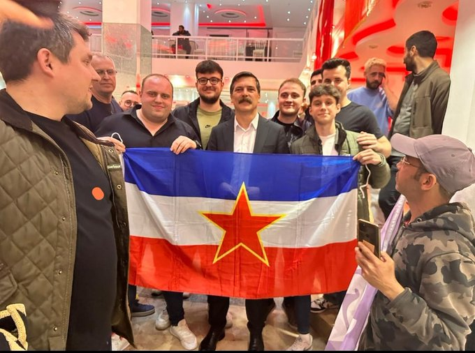 Turkish Workers' Party chairman Erkan Baş holding a Yugoslav flag in his meeting with Bosniak socialists. He is Bosniak himself and grew up speaking the Bosnian language.