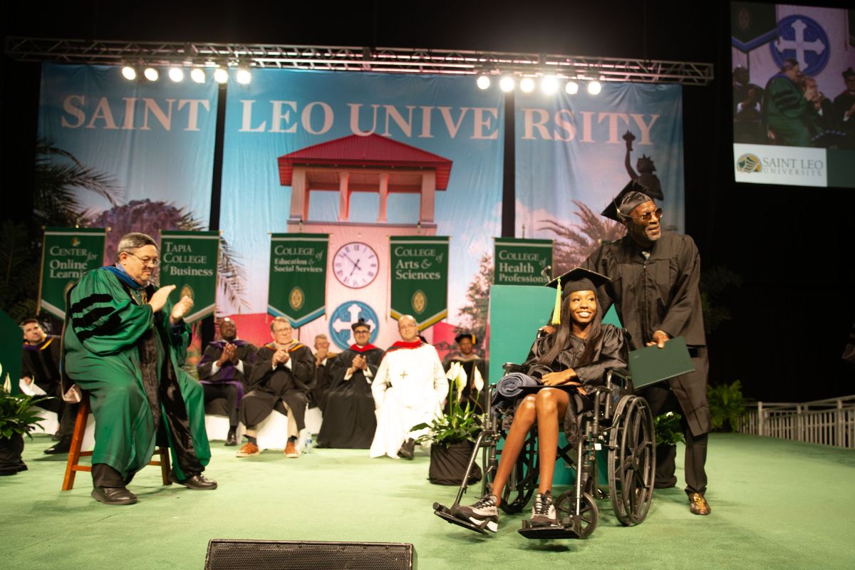 SaintLeoUniv's tweet photo. Trustee and alumnus Kevin Sullivan ’13 officially welcomed this afternoon’s graduates to the alumni association. "You may now turn your tassels from right to left. In doing so, please note that the tassel is over your heart. May Saint Leo always be within your heart." https://t.co/3XRVilLB2Y