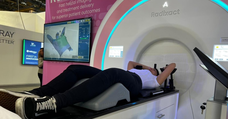Accuray's tweet photo. Thank you @Orfit for letting us showcase its MammoRx Breast Board to allow us to demo VitalHold for #Radixact. #ESTRO23 #CertaintyMatters