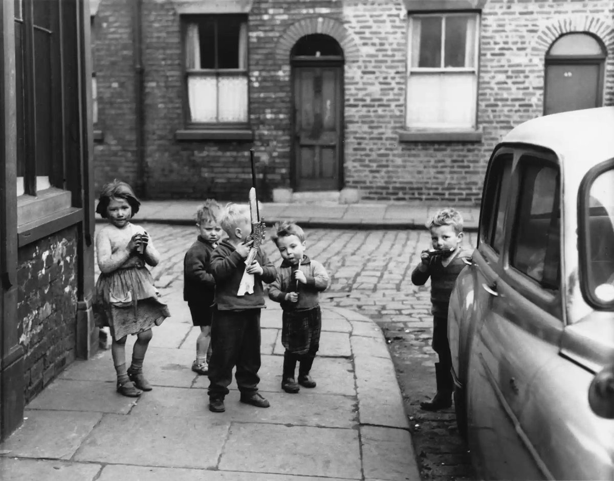 Shirley Baker. Children playing on a street corner, Manchester, 1961.