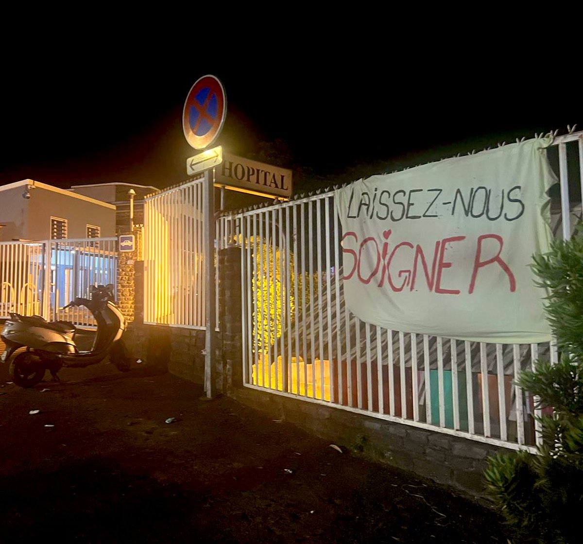 LouisWitter's tweet photo. Depuis plus de dix jours, des collectifs bloquent l’accès à l’hôpital et aux dispensaires de Mayotte pour empêcher aux étrangers d’accéder aux soins.

Ce soir, des soignants en colère ont exprimé leur ras-le-bol avec une banderole, « Laissez-nous soigner ». https://t.co/ondqjYAZHP