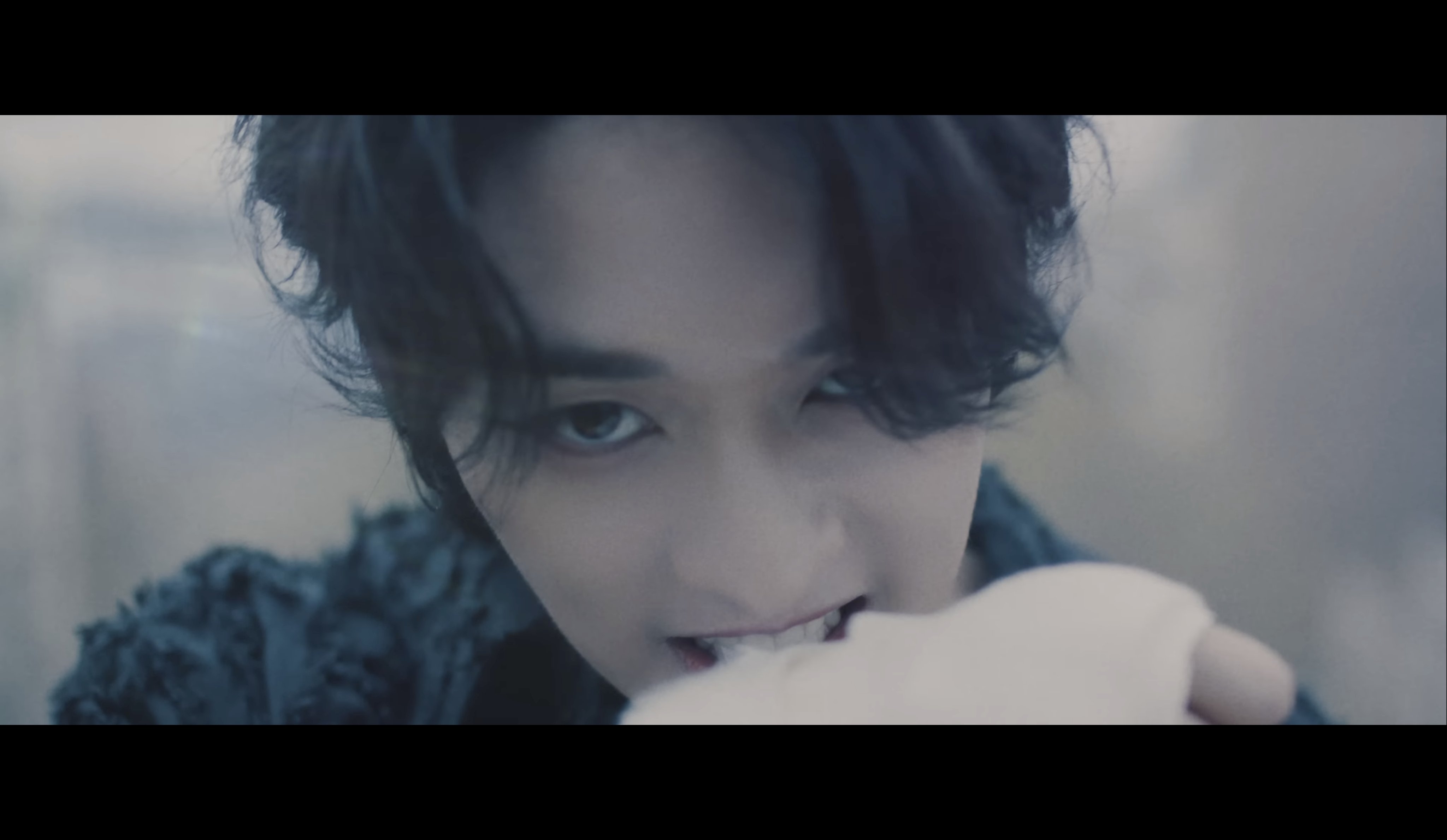  A man with long black hair and dark eyes is shown in the image. He is looking at the camera with an intense expression. The image is dark and moody. It represents the search query 'Download high-quality Twitter videos' because it depicts the intensity and excitement of finding and downloading high-quality videos from Twitter.