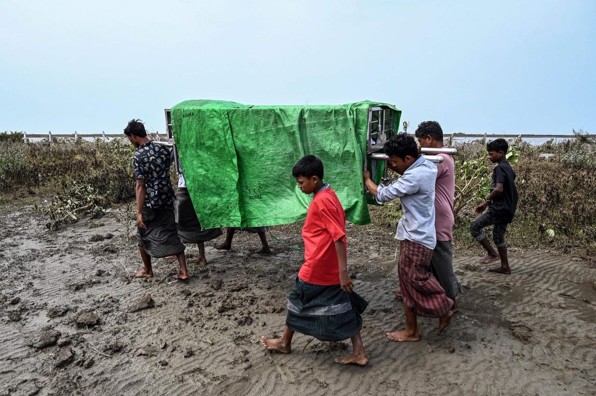 People carry the body of a victim of Cyclone Mocha for burial during a funeral near Basara internally displaced persons' camp in Sittwe, Rakhine State, on Tuesday after the storm made landfall two days earlier.  #HelpMyanmar #2023May16Coup #WhatsHappeningInMyanmar
