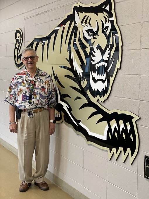 Mr. Skip Moroz posing next to the art installation of a Bengal in the front foyer of OFHS.