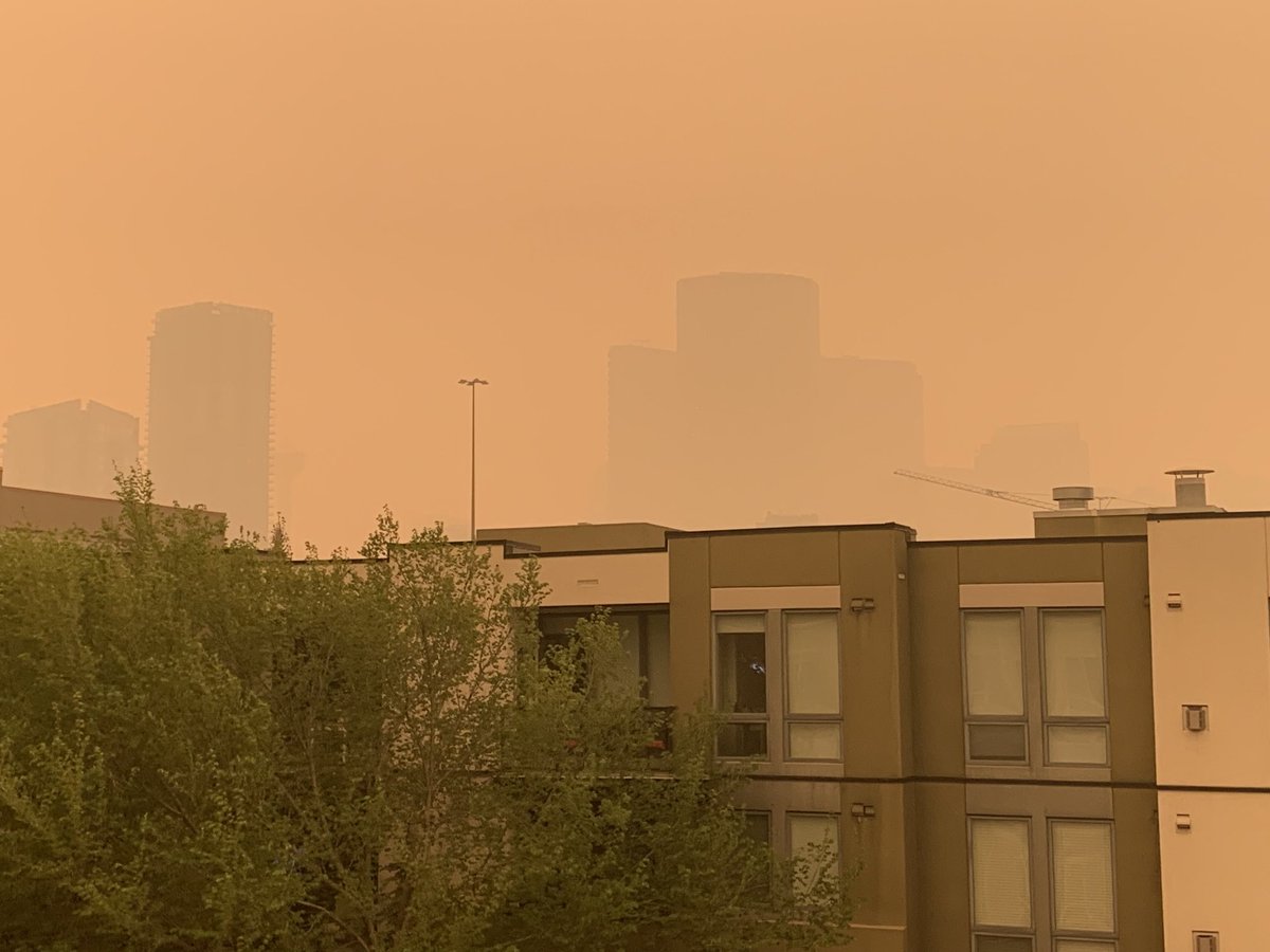 MonicaZurowski's tweet photo. Never before has the Calgary Tower disappeared from the skyline view I get from my condo (in #Bridgeland.) But, today it can’t be seen! This is the most intense smoky sky I’ve ever seen in yyc. #ABFires #ABWildfires #smoke #smokysky https://t.co/c6XrT5pcLp