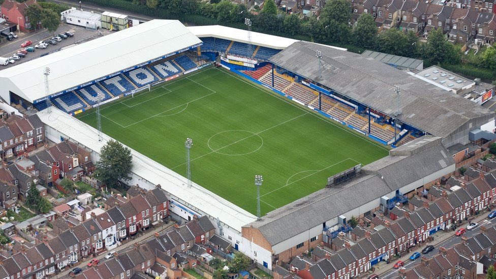 Juezcentral's tweet photo. Hoy, el Luton, que hace 9 años estaba en quinta división, venció al Sunderland y quedó a un partido de llegar a la Premier League. 

Su estadio fue inaugurado en 1905. Para ingresar a las tribunas, se entra  por las casas de los vecinos, pasando por sus jardines. Fútbol inglés💙⚽️.