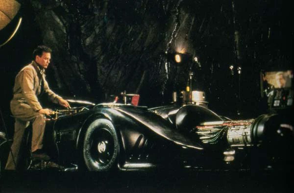 Photos of Michael Keaton's Bruce Wayne in his Mechanic Jumpsuit working on The Batmobile (worn only in this once scene), from Batman Returns. It's cool to see Bruce actually working on the car like this. Also surprised there isn't a figure or statue of this yet.