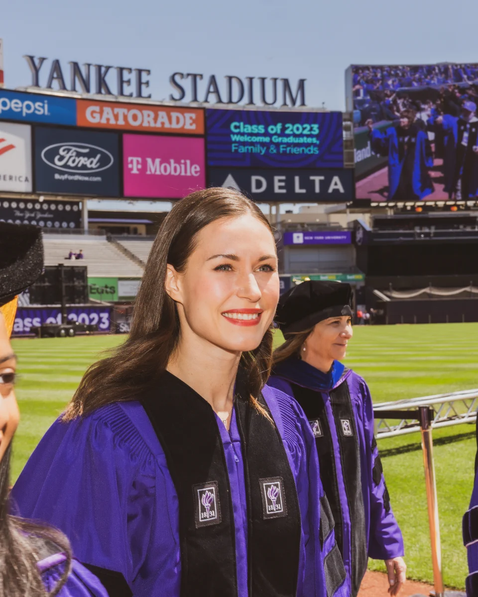 Sanna Marin in NYU purple academic attire at Yankee Stadium