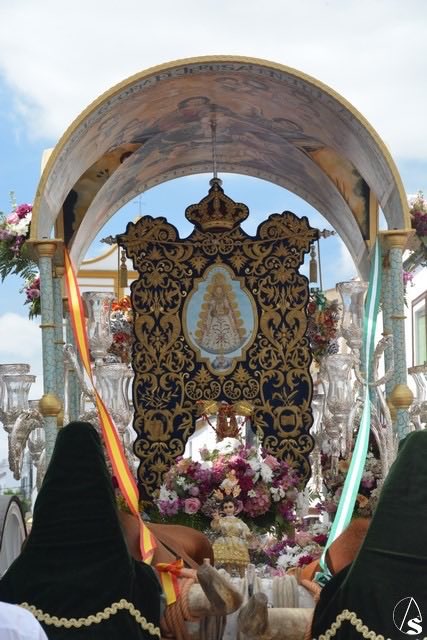 Simpecado azul noche en oro bordado con la virgen del Rocío en el centro marcado.
Simpecado en la carreta pintada y con flores adornada, arropada con cantes por sevillanas.
Y la Hdad. De Nuestra Señora Del Rocío de Marchena se va hacia la aldea un domingo por la mañana.
