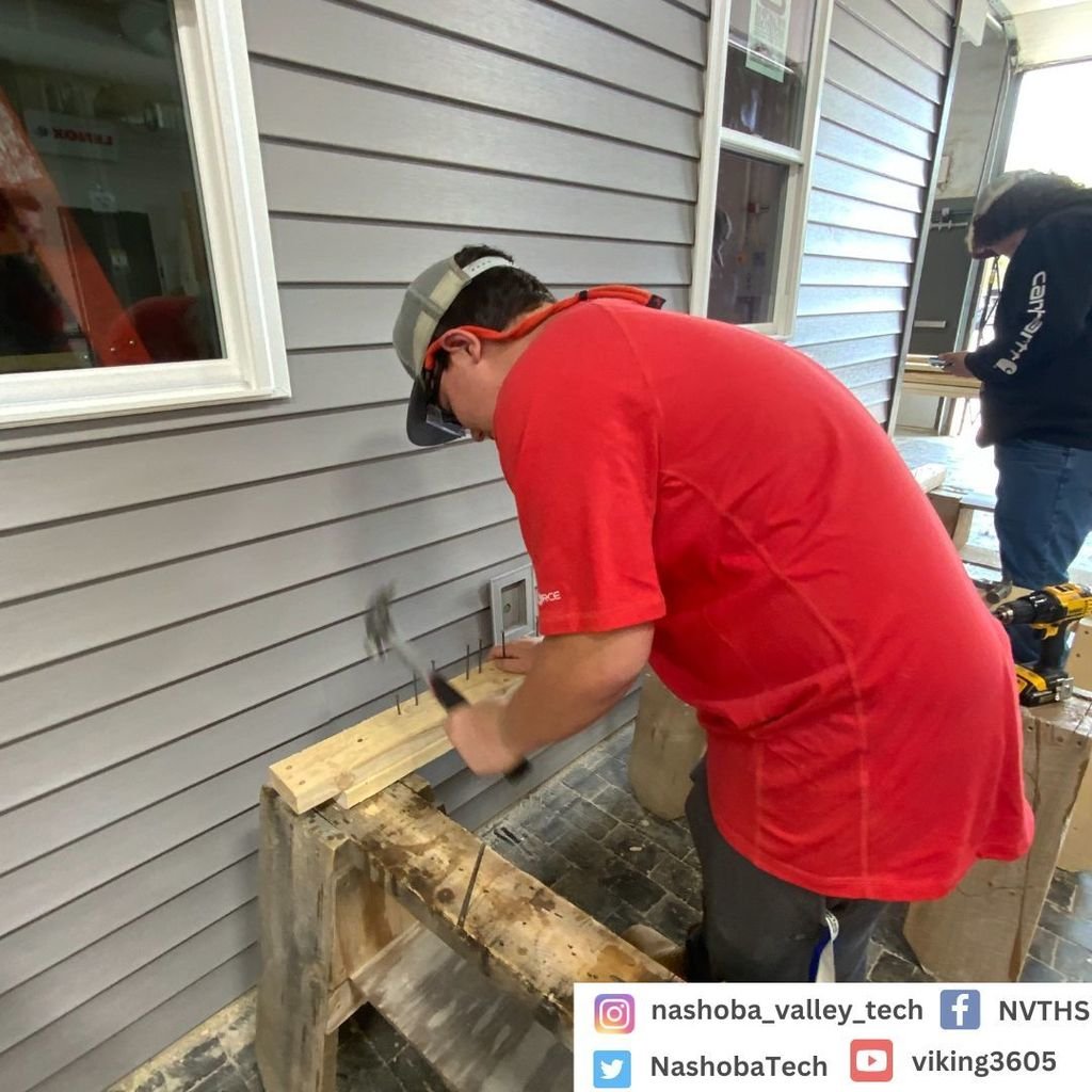 Building Dreams at NVTHS. The Carpentry shop has been hard at work constructing a mock house. Here we have a student using a chop saw to cut the frames of the wood to length.