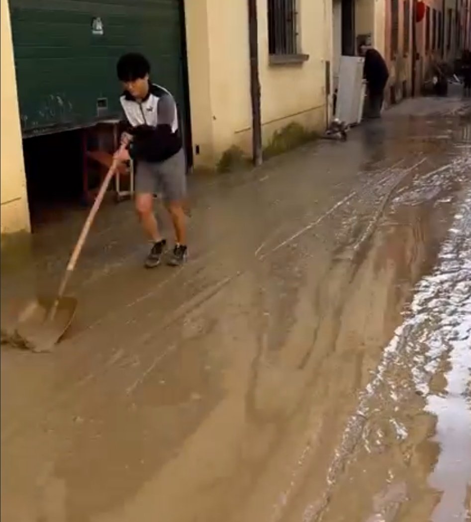 Yuki Tsunoda ajudando na limpeza da lama em Faenza, cidade onde fica a sede da AlphaTauri.