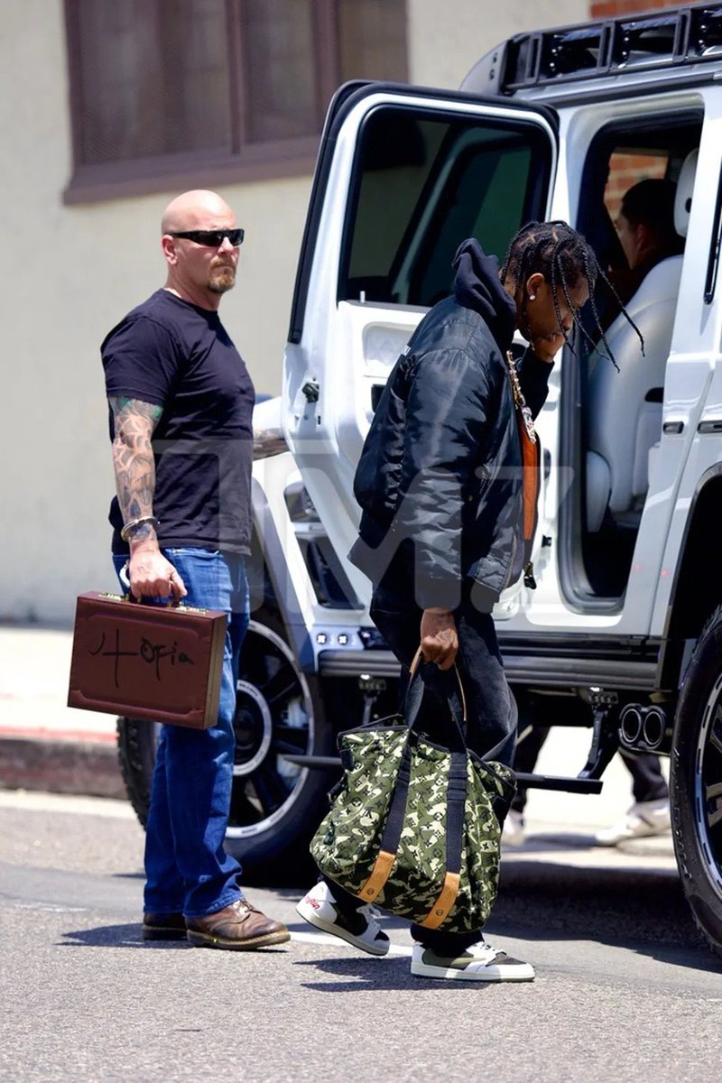 STRAPPEDUS's tweet photo. Travis Scott’s bodyguard has a UTOPIA briefcase handcuffed to his wrist 🌵

The briefcase most likely contains a hard drive or laptop with the album on it 👀 https://t.co/C9wdG78KbZ
