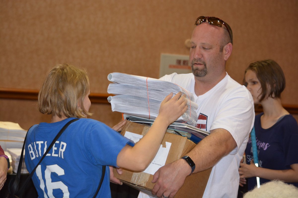 Here's a #TBT photo from #NFB19. We love it when #BlindKids find #BrailleBooks to take home from the #BrailleBookFair like this child featured in this photo handing a stack of books to their dad. Who's excited for the Braille Book Fair at  #NFB23?
