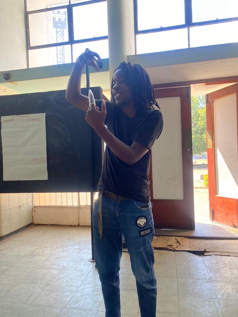 One of the young participants demonstrating how to use a condom to his peers