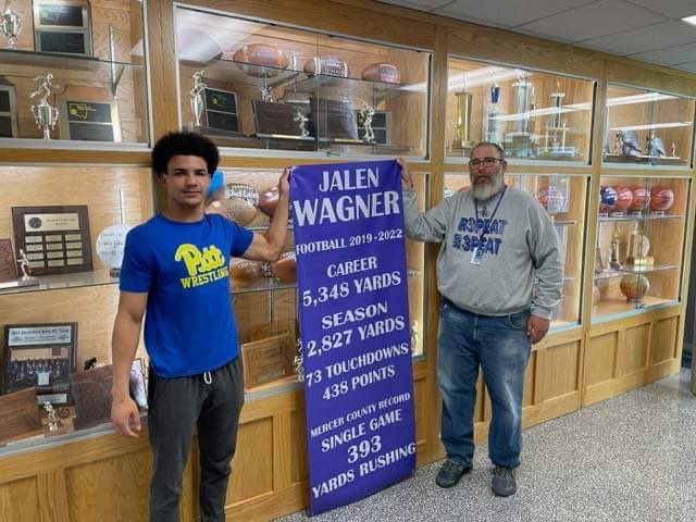 Reynolds football great Jalen Wagner stands next to the banner that will hang forever inside the Raiders gymnasium. <a href="/RHS_Football/">RHS Football</a> <a href="/Jalen_Wagner27/">Jalen Wagner</a>