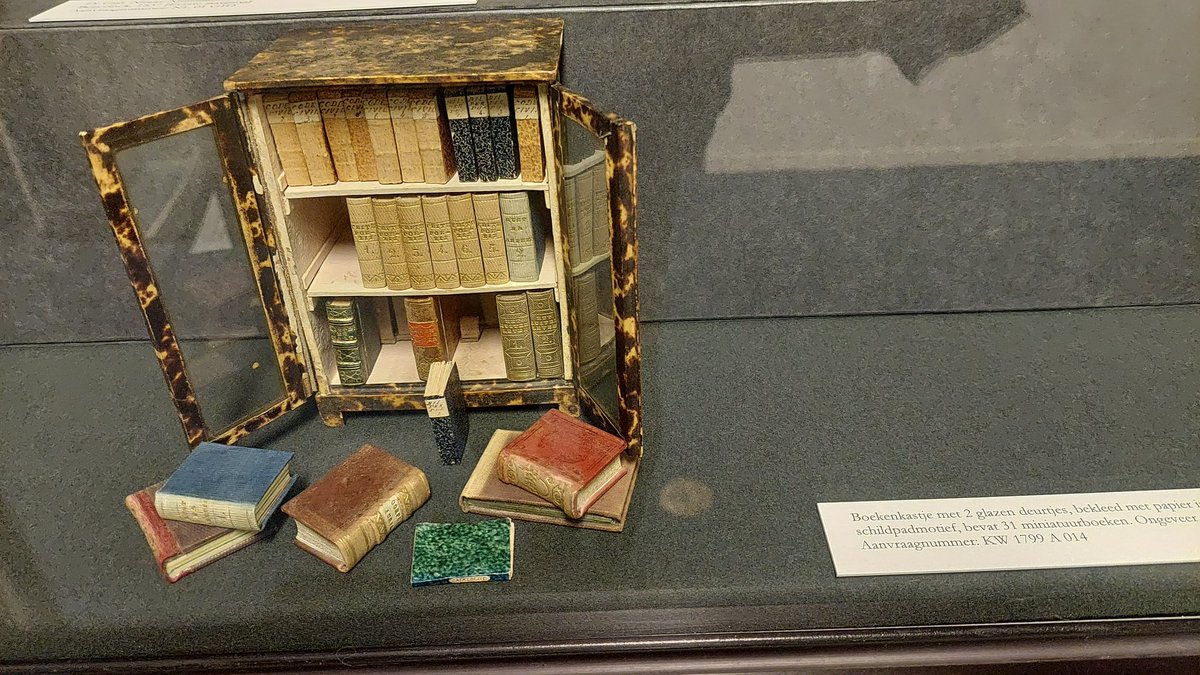 Mini boekenkast, niet groter dan een pak suiker. Met glazen deurtjes. 1840. Geweldig! In de KB, aanvraagnummer KW 1799 A 014.