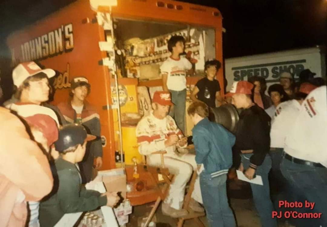 Mid August 1984
Bobby Allison signing autographs in the pits at Fonda Speedway.

Little RJ in the white t-shirt next to Bobby. 
Photo by PJ O'Connor
