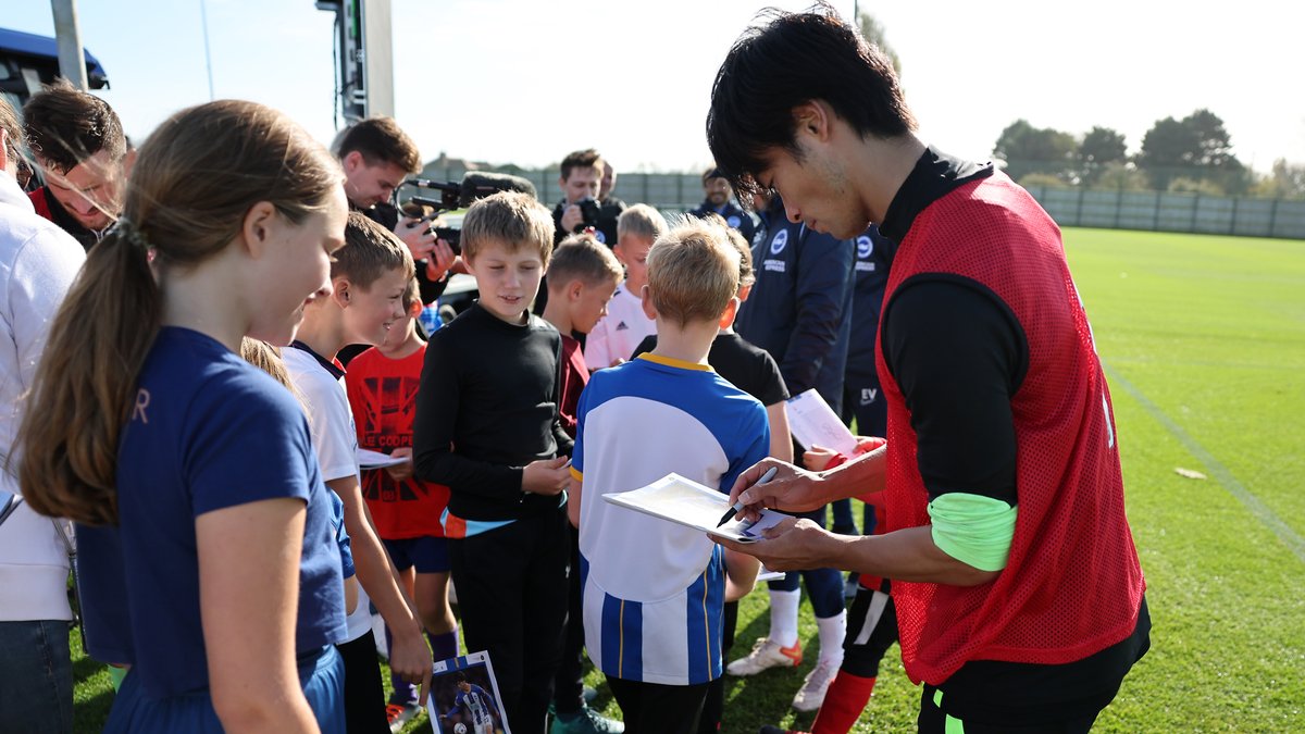 Kaoru signing items for a group of young Sussex-based Ukrainians when they were invited down to the training ground
