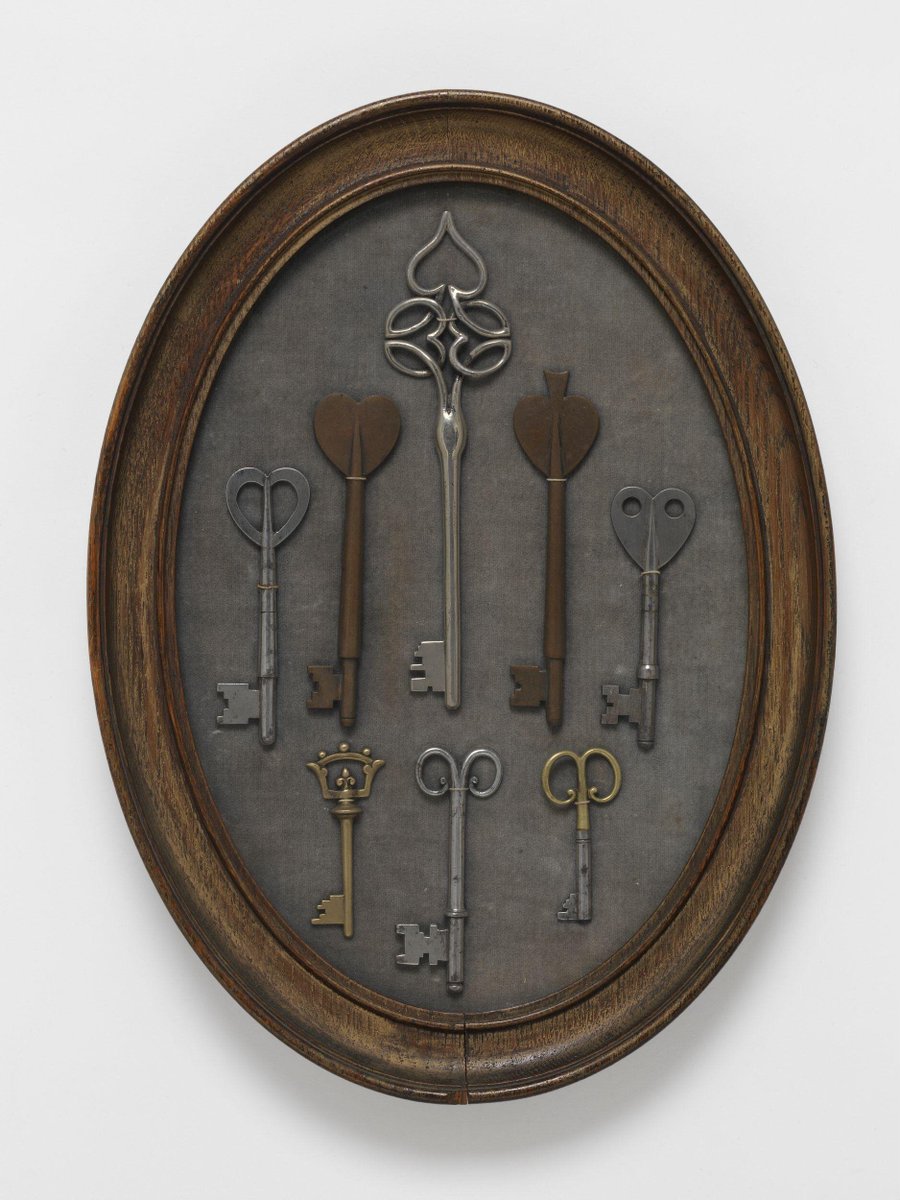Eight keys, set within an oval frame, brass, steel and bronzed metal, London, ca.1900, possibly made by William Bainbridge Reynolds, designed by C.F.A. Voysey. Victoria & Albert Museum.