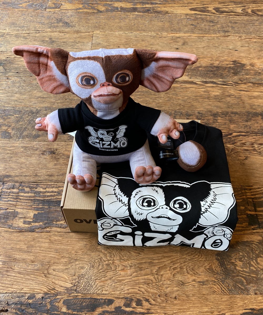 phase_next's tweet image. OVER THE STRiPES×GREMLINSオフィシャルアイテム!!!  
 &quot;PLUSH DOLL GIZMO&amp;amp;TEE BOX SET&quot;   

 起毛素材にリアルな絵を昇華転写プリントで表現。   
ボックスの中にはTシャツとその色に合わせたギズモのフィギュアが同梱されています。  
item.rakuten.co.jp/whn/otsg-01t/