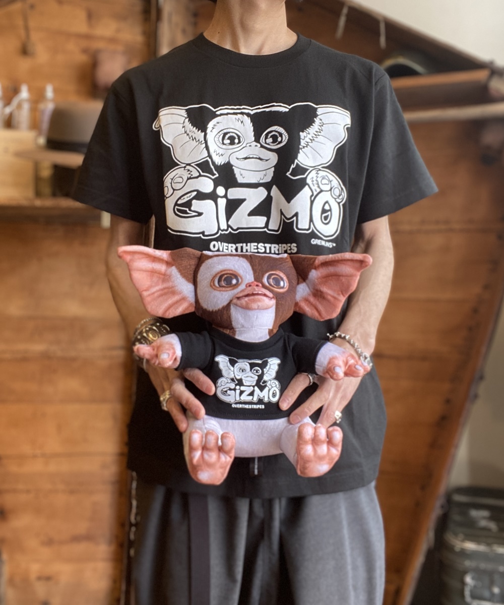 phase_next's tweet image. OVER THE STRiPES×GREMLINSオフィシャルアイテム!!!  
 &quot;PLUSH DOLL GIZMO&amp;amp;TEE BOX SET&quot;   

 起毛素材にリアルな絵を昇華転写プリントで表現。   
ボックスの中にはTシャツとその色に合わせたギズモのフィギュアが同梱されています。  
item.rakuten.co.jp/whn/otsg-01t/