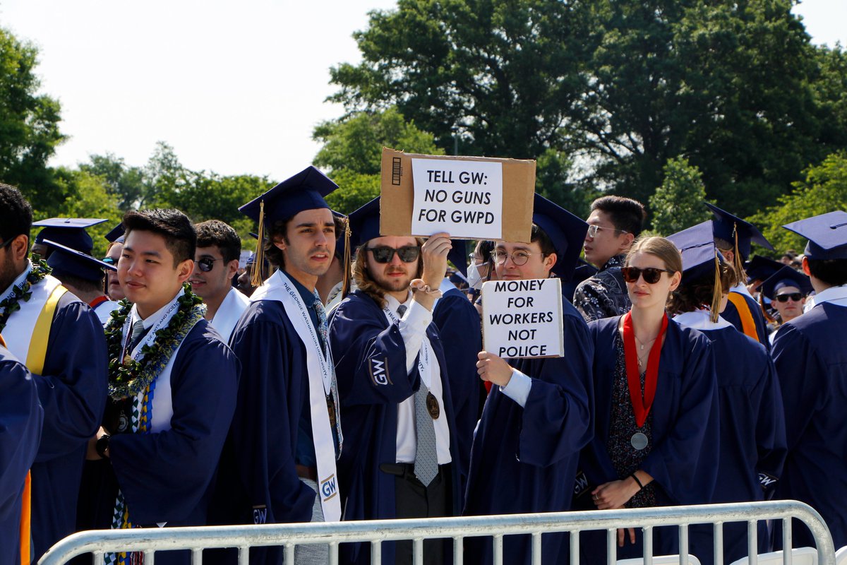 gwhatchet's tweet photo. PHOTO: Students protested the Board of Trustees' recent decision to arm some GW Police Department officers throughout the Commencement ceremony Sunday. Photos by @SageRussell13 and @audenyurman https://t.co/pxW1iZrGJ5