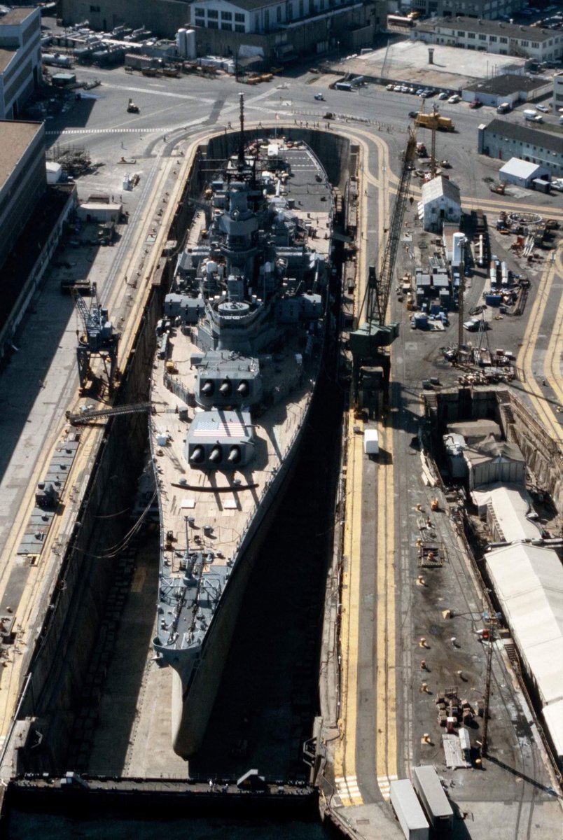 combatpix1's tweet image. An aerial view of the #USSIowa (BB-61), the lead ship of her class of 45,000-ton battleships, in Dry Dock No. 4 at Norfolk Naval Shipyard, 1 May 1985. Iowa was reactivated in 1984 as part of President Reagan's plan for a 600-ship #Navy.