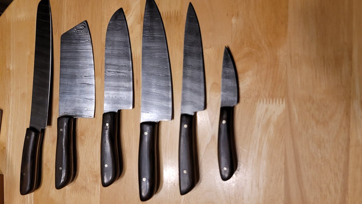 OfficialFarEm's tweet photo. I've been making knives recently. Here's a 6 piece kitchen knife set with leather/canvas chef's roll. Knives are high carbon ladder damascus with Ziricote handles and Red Micarta spacers. Client requested that they be "rustic" so some tooling marks were left intentionally. https://t.co/Sv5aLxT9vw