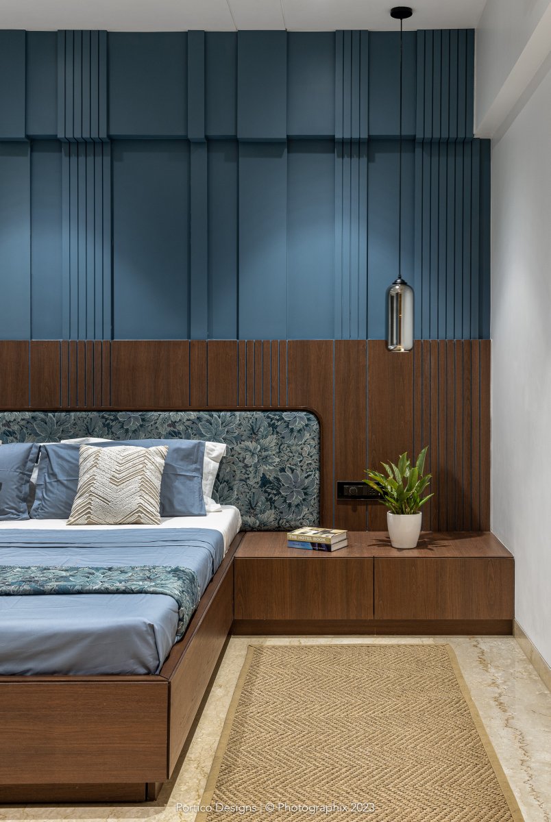 This bedroom of the Pune apartment had a better length. This allowed us to play with the bed-back wall — which has been highlighted by painting it a deep blue and giving it a rhythmic 3D pattern. #interiordesign #porticodesignconcepts #porticointeriors