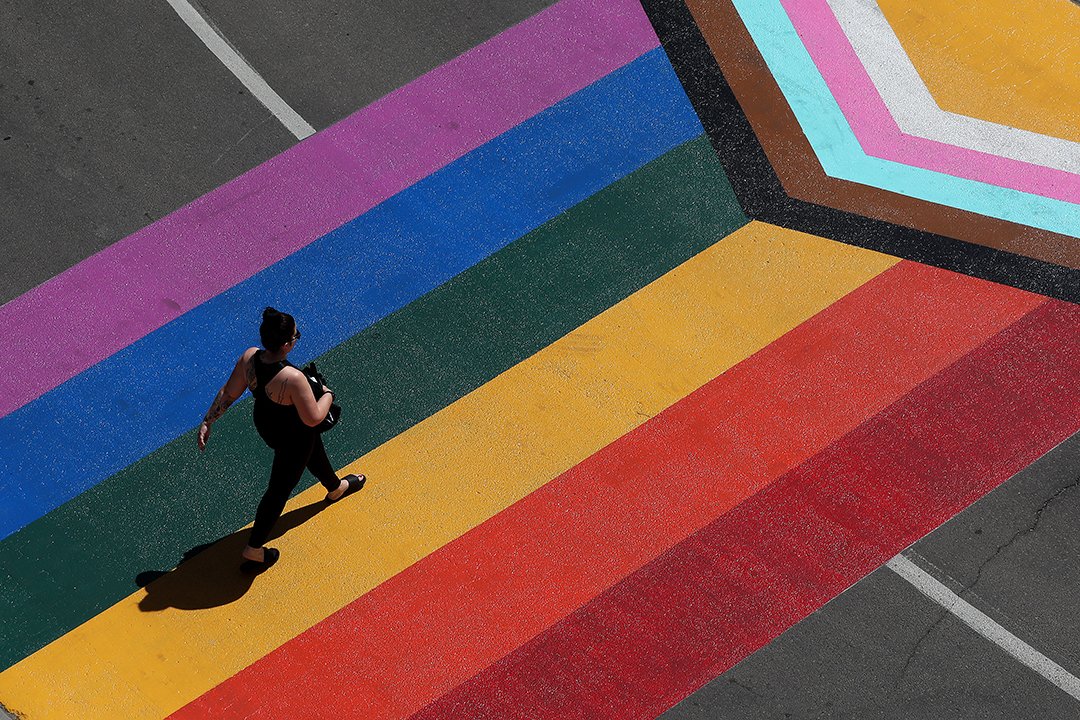 A pedestrian makes their way across a Pride Flag crosswalk outside @kingswaymall in #yeg Tuesday. #Pride2023